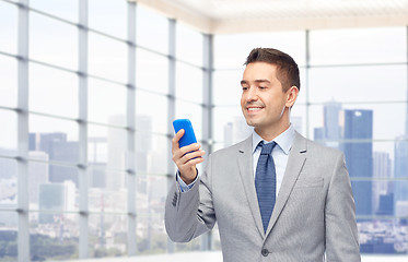 Image showing happy businessman texting on smartphone