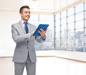 Image showing happy businessman in suit holding tablet pc