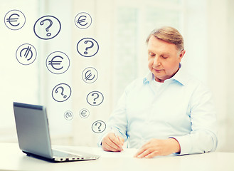 Image showing old man filling a form at home