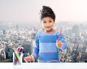 Image showing happy little girl drawing with coloring pencils