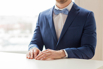 Image showing close up of man in suit and bow-tie at table