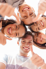 Image showing group of smiling teenagers looking down