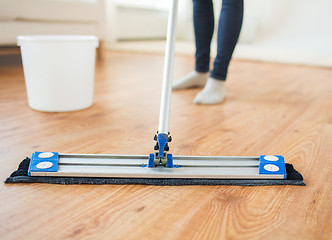 Image showing close up of woman with mop cleaning floor at home