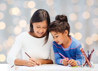 Image showing happy mother and daughter drawing with pencils