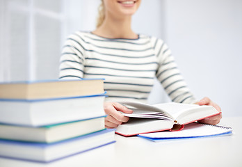 Image showing close up of young woman reading book at school