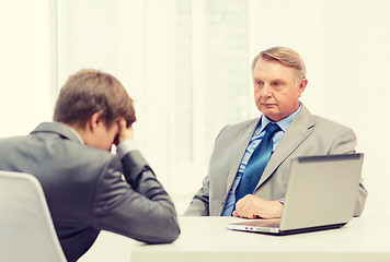 Image showing older man and young man having argument in office