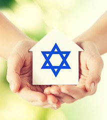 Image showing close up of hands holding house with star of david