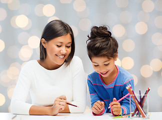 Image showing happy mother and daughter drawing with pencils