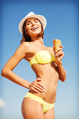 Image showing girl in bikini eating ice cream on the beach