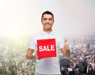 Image showing smiling man with red sale sigh showing thumbs up