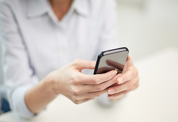 Image showing close up of woman texting on smartphone at office