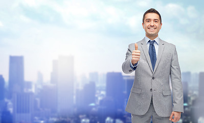 Image showing happy businessman in suit showing thumbs up