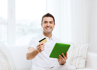 Image showing smiling man working with tablet pc at home