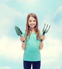 Image showing smiling little girl with rake and scoop