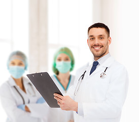 Image showing smiling male doctor with clipboard and stethoscope