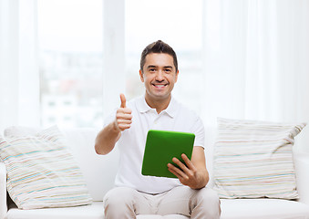 Image showing smiling man working with tablet pc at home