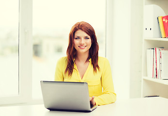 Image showing smiling student with laptop computer at school