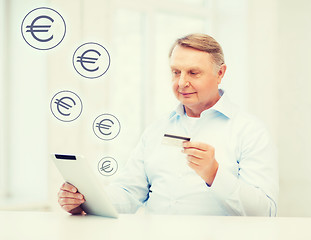Image showing old man with tablet pc and credit card at home