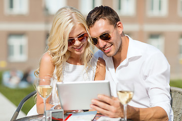 Image showing couple looking at tablet pc in cafe