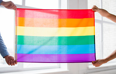 Image showing close up of male gay couple holding rainbow flag