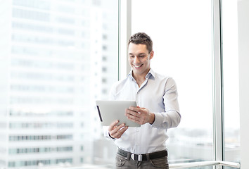 Image showing smiling businessman with tablet pc in office