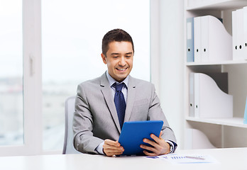 Image showing smiling businessman with tablet pc in office