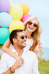 Image showing couple with colorful balloons at seaside