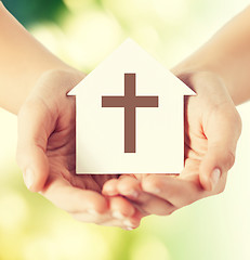 Image showing close up of hands and paper house with cross