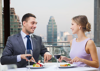 Image showing smiling couple eating and talking at restaurant