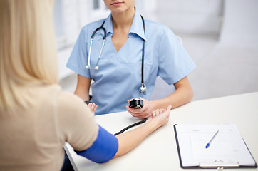 Image showing close up of doctor and woman measuring pressure