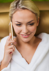 Image showing beautiful young woman with smartphone at spa