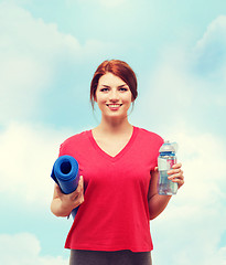 Image showing smiling girl with bottle of water after exercising