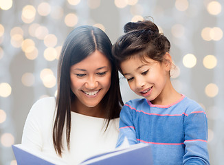 Image showing happy mother and daughter reading book