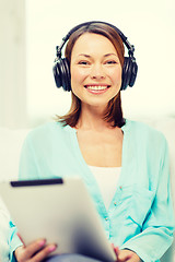 Image showing smiling woman with tablet pc and headphones