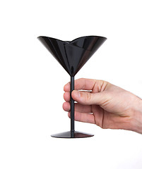 Image showing Black plastic coctail glass in hand