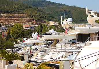 Image showing Row of luxury motorised yachts moored in a sheltered harbour