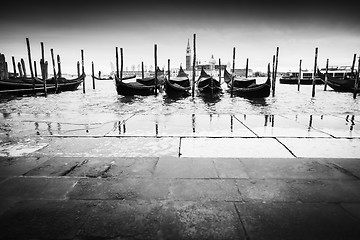 Image showing Gondolas moored in front of pavement bw