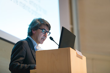 Image showing Speaker giving talk on podium at Business Conference.