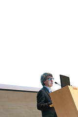 Image showing Speaker giving talk on podium at Business Conference.