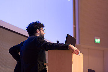 Image showing Speaker giving talk on podium at Business Conference.