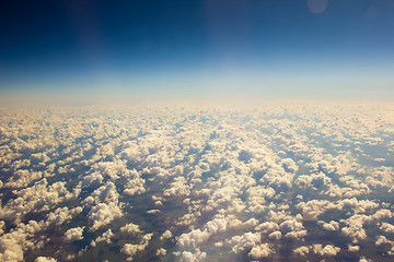 Image showing White clouds in blue sky. Aerial view from airplane.