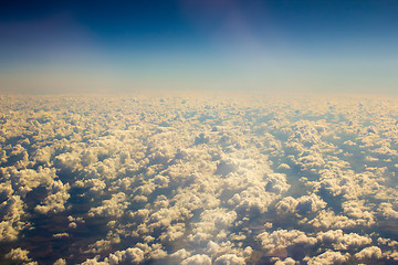 Image showing White clouds in blue sky. Aerial view from airplane.