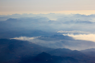 Image showing White clouds in blue sky. Aerial view from airplane.