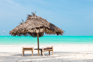 Image showing Two deck chairs and umbrella on tropical beach.