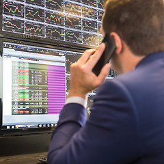 Image showing Stock trader looking at computer screens.