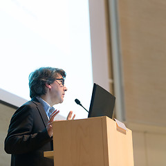 Image showing Speaker giving talk on podium at Business Conference.