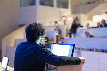 Image showing Speaker giving talk on podium at Business Conference.