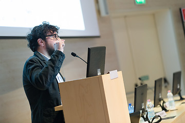 Image showing Speaker giving talk on podium at Business Conference.