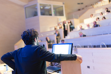 Image showing Speaker giving talk on podium at Business Conference.