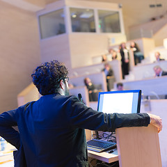 Image showing Speaker giving talk on podium at Business Conference.